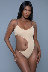 Woman wearing a beige bodysuit against a gray background