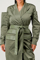 Green trench coat worn by a person on a white background