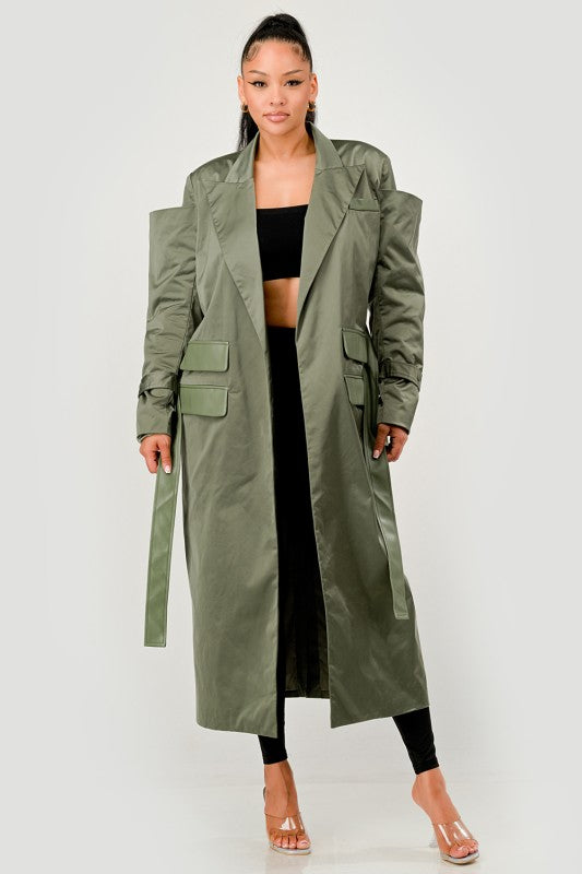 Woman wearing a long olive green coat on a white background