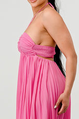 Pink halter neck dress worn by a person on a white background