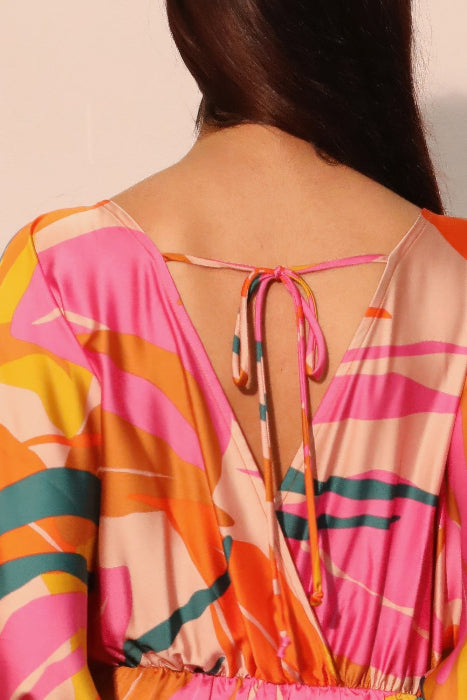 Colorful patterned jumpsuit with open back on a plain background