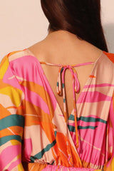 Colorful patterned jumpsuit with open back on a plain background