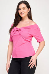 Woman wearing a pink off-shoulder top with a knot detail on a white background