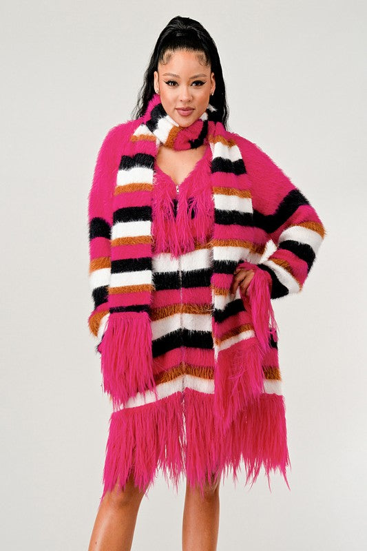 Woman wearing a colorful striped cardigan with fringes on a white background