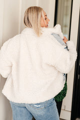 Person wearing a white fluffy jacket with a blurred background
