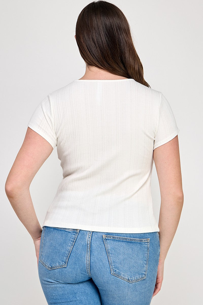 Woman wearing a white t-shirt and blue jeans on a plain background