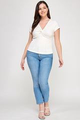 Woman wearing a white top and light blue jeans on a white background
