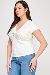 Woman wearing a white ruched top and blue jeans on a white background