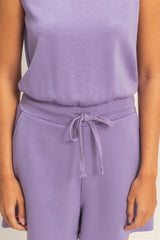 Person wearing a purpleromper with a drawstring waistband.