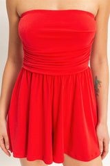 Red strapless romper worn by a woman on a plain background