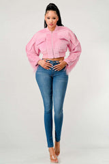 Woman wearing a pink jacket and blue jeans on a white background