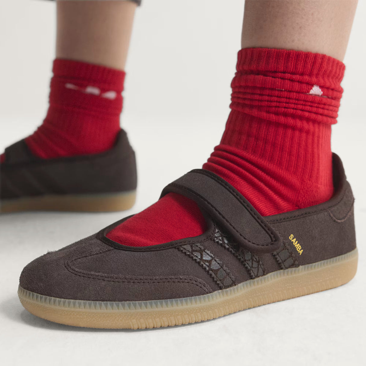 Brown Adidas Samba Jane Mary Jane Sneakers with red socks on a light background