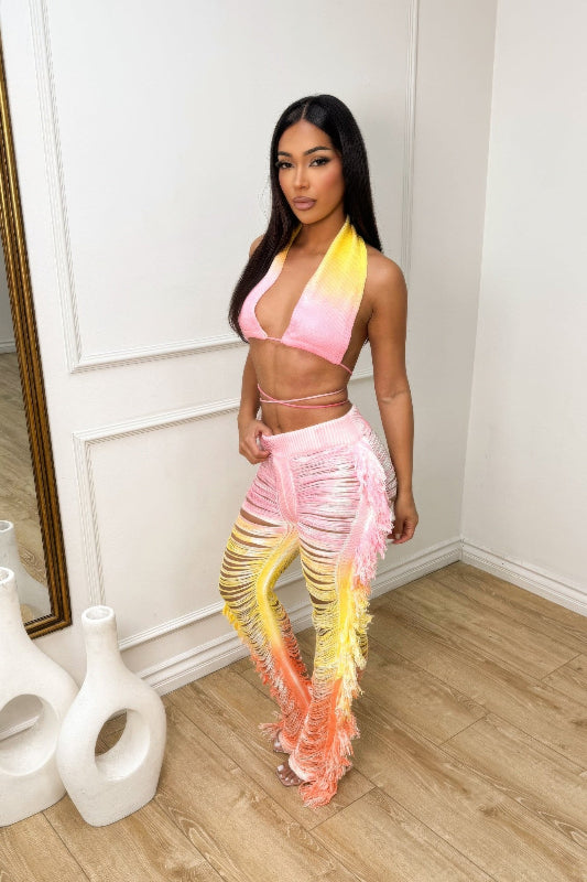 Woman wearing a colorful outfit in a room with white walls and wooden floor.