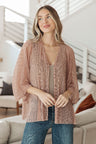 Woman wearing a pink textured cardigan in a living room setting