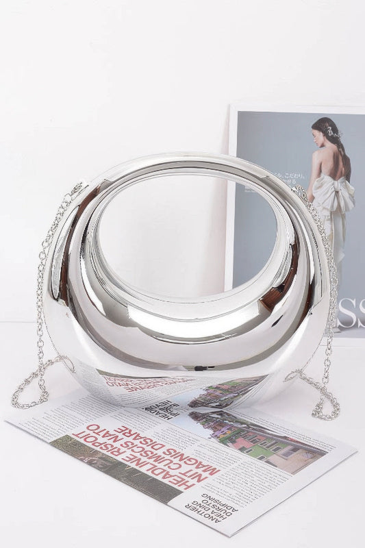 Silver metallic handbag with chain on a magazine