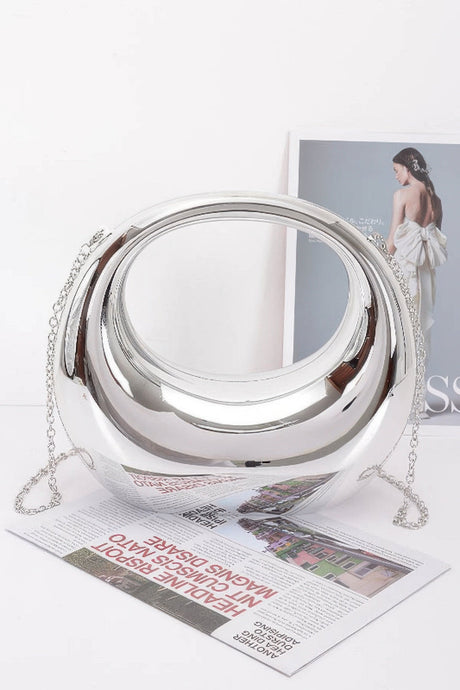 Silver metallic handbag with chain on a magazine