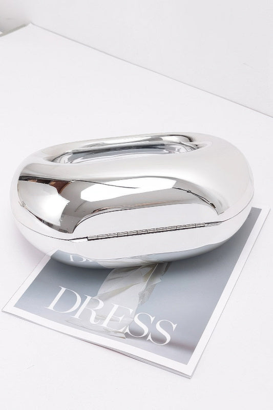 Silver metallic handbag on a magazine with 'DRESS' text