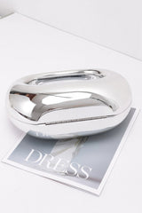 Silver metallic handbag on a magazine with 'DRESS' text
