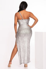 Woman wearing a silver sequin dress with a slit on a white background back view