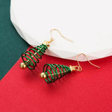 Green spiral earrings with gold accents on a red and green background
