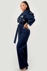 Woman wearing a denim jumpsuit with ruffles on a white background