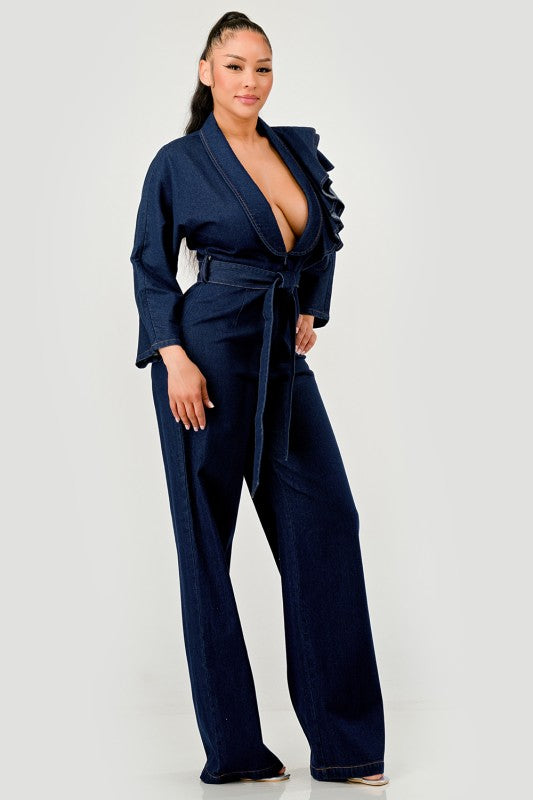 Woman wearing a dark denim jumpsuit on a white background