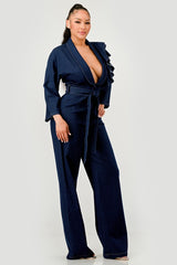 Woman wearing a dark denim jumpsuit on a white background