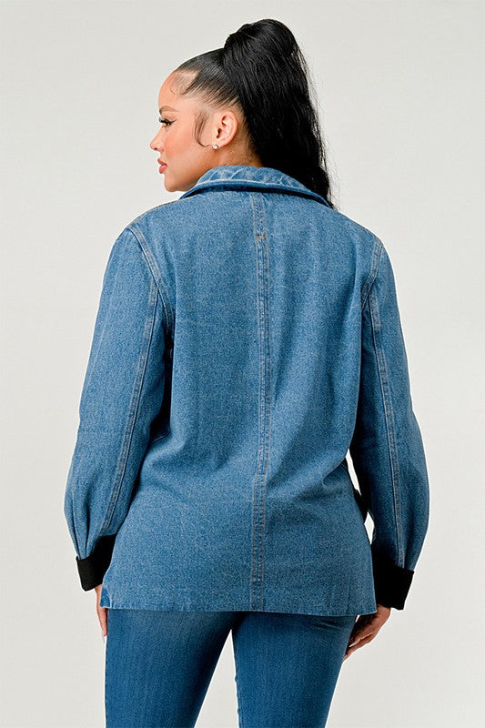 Woman wearing a blue denim jacket on a plain background