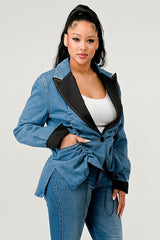 Woman wearing a blue denim suit with black lapels on a white background
