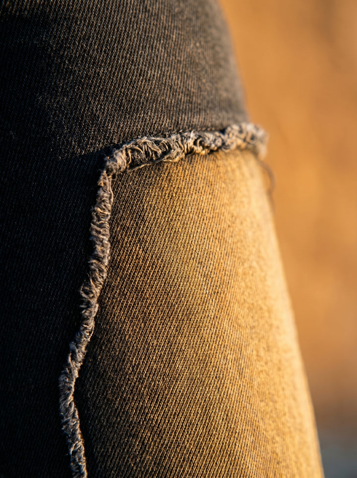 Close-up of a person wearing distressed jeans with a blurred background
