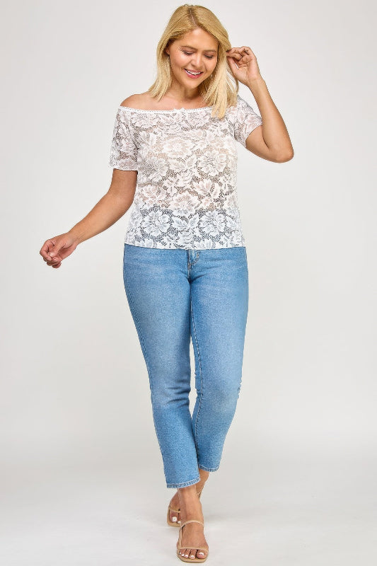 Woman wearing a lace top and blue jeans on a white background