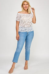 Woman wearing a white lace top and blue jeans on a white background