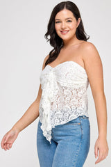 Woman wearing a white lace strapless top and blue jeans on a white background