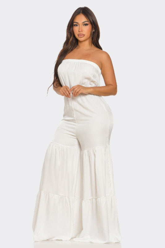 Woman wearing a white strapless jumpsuit on a white background