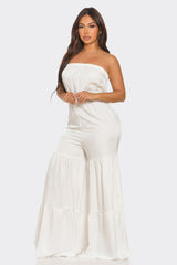 Woman wearing a white strapless jumpsuit on a white background