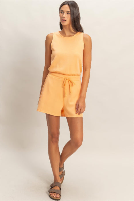 Woman wearing a peach-colored Drawstring Waist Sleeveless Romper on a plain background
