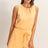 Woman wearing a yellow Drawstring Waist Sleeveless Romper on a plain background